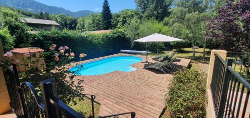 a swimming pool with an umbrella and a table and chairs at 4 Bedroom Villa with Private Pool within 5 minute walk into Quillan in Quillan
