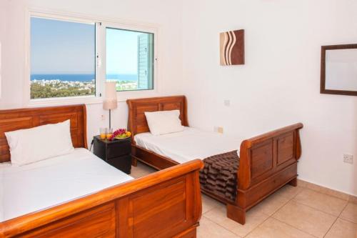 - une chambre avec 2 lits et une vue sur l'océan dans l'établissement Villa Ourania, à Protaras