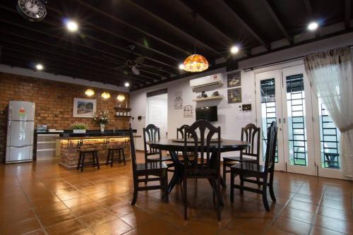 uma cozinha e sala de jantar com mesa e cadeiras em Harmonia Homestay em Malaca