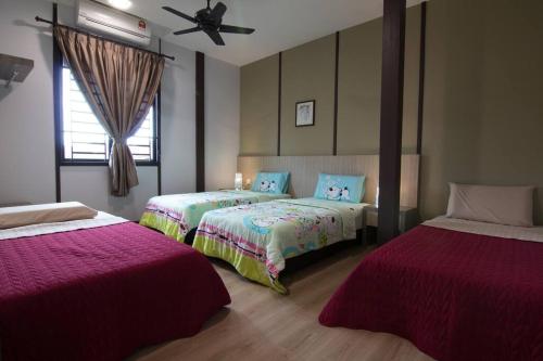 una camera con 2 letti e un ventilatore a soffitto di Harmonia Homestay a Malacca