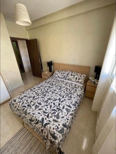 1 dormitorio con 1 cama con edredón azul y blanco en Appartement en résidence avec parking en Marrakech