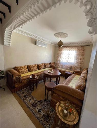 sala de estar con sofá y mesa en Appartement en résidence avec parking en Marrakech