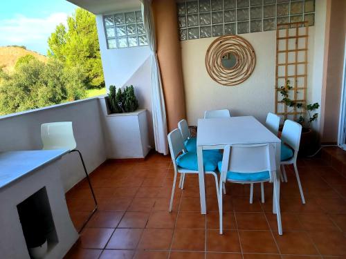 ein Esszimmer mit einem Tisch, Stühlen und einem Fenster in der Unterkunft Hacienda Dona JULIA GOLF Estepona in Casares