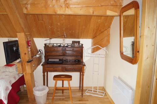 ein Schlafzimmer mit einem Schreibtisch in einem winzigen Haus in der Unterkunft Chambres d'hôtes Au Doubs Murmure in Les Fins
