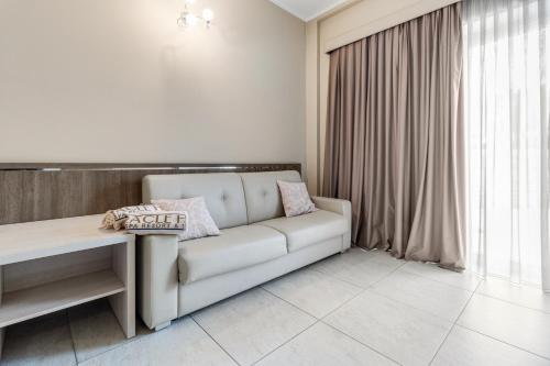 a white couch in a room with a window at Eracle Hotel in Volla