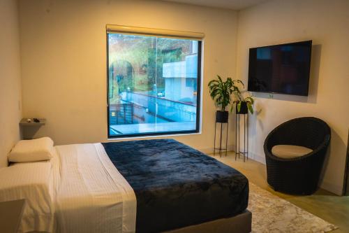 - une chambre avec un lit et une grande fenêtre dans l'établissement Villa La Gema, à Medellín