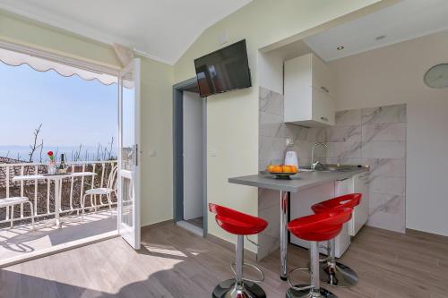 una cucina con sgabelli rossi e un balcone di Villa NIKA & KARLO Makarska a Makarska