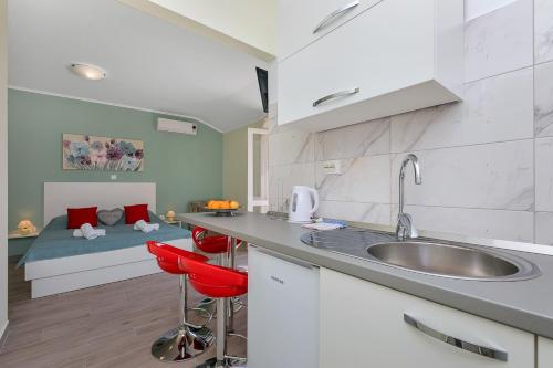 a kitchen with a sink and a bed in the background at Villa NIKA & KARLO Makarska in Makarska