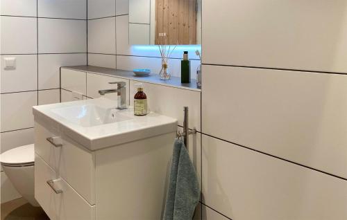 a white bathroom with a sink and a toilet at Awesome Home In Simrishamn With House Sea View in Simrishamn