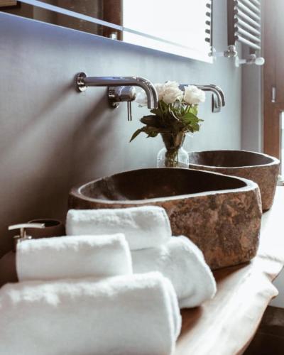 a bathroom with a sink and a bunch of towels at KeRo Luxury Rooms in Cagliari