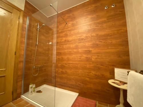 y baño con ducha y paredes de madera. en Jardin de la Yedra, en Cáceres
