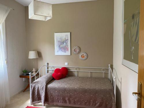 a bedroom with a bed with a red pillow on it at Jardin de la Yedra in Cáceres