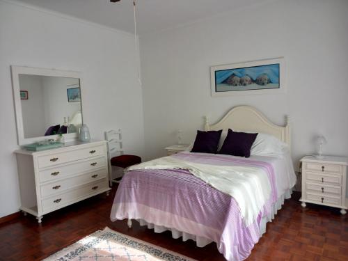 a bedroom with a bed and a dresser and a mirror at Casa Branca in Lagoa