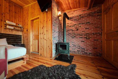 a bedroom with a fireplace and a bed and a stove at Abant Yayla Dağevi in Dereceören