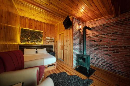 a bedroom with a bed and a stove in a room at Abant Yayla Dağevi in Dereceören