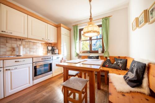 a kitchen with a wooden table and a dining room at Alpenrose in Grainau