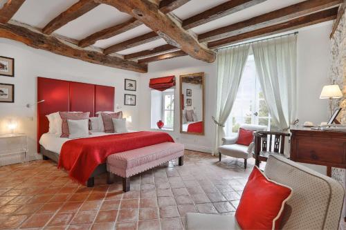 a bedroom with a large bed with a red blanket at La Chartreuse du Bignac - Teritoria in Saint-Nexans