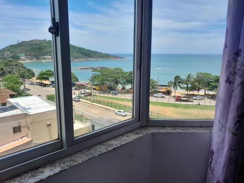 a window with a view of the ocean at Apartamento com vista para o mar em Setiba Guarapari in Guarapari