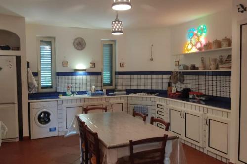 una cocina grande con mesa y sillas. en Villa del glicine, en Muro Leccese