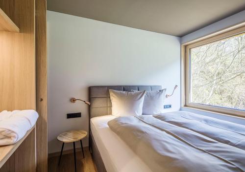 sypialnia z dużym łóżkiem i oknem w obiekcie freiraum Apartments w mieście Mellau