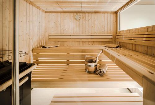 a wooden sauna with a bucket in the middle at freiraum Apartments in Mellau