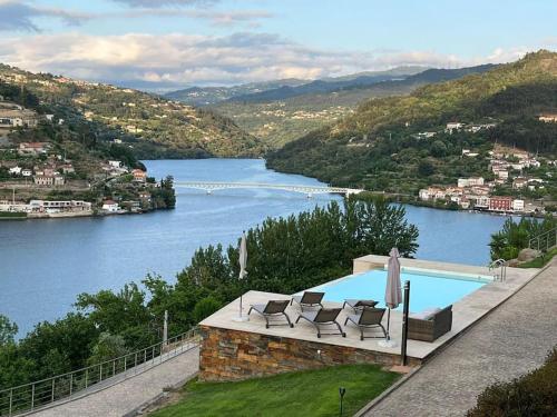 a swimming pool with chairs and a view of a river at Casa das Oliveiras, o Douro no seu esplendor! in Cinfães
