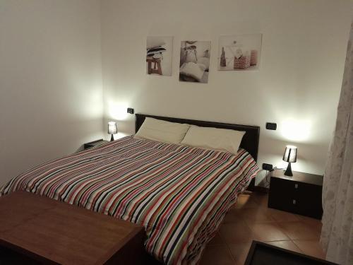 オメーニャにあるCasa al lagoのベッドルーム1室(ベッド1台付)が備わります。壁に2枚の写真が飾られています。