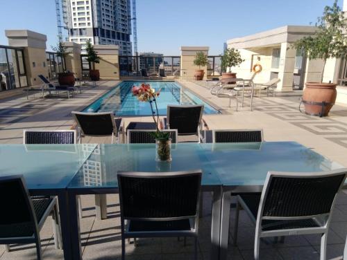 a table and chairs on a rooftop with a pool at Michelangelo Towers 0801 in Johannesburg