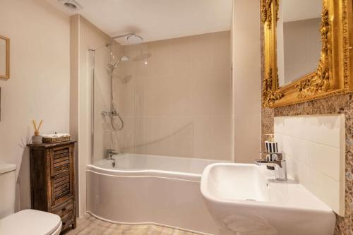 een badkamer met een bad, een wastafel en een toilet bij The Cotswold Lady in Guiting Power