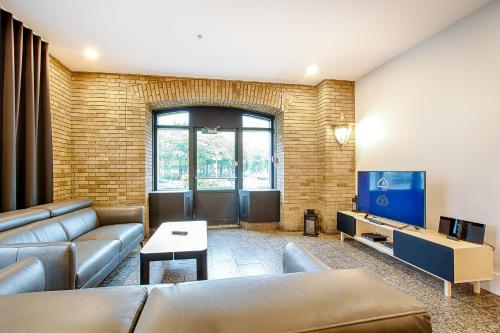 a living room with a couch and a tv at Les Lofts de la Gare - Par Les Lofts Vieux-Québec in Quebec City