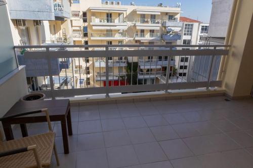 克桑西的住宿－Luxury apartment in the center of Xanthi，阳台配有桌子,享有建筑的景致。