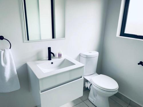 een witte badkamer met een wastafel en een toilet bij The Blyde Crystal Lagoon Bliss in Pretoria