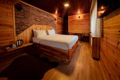 a bedroom with a bed in a wooden room at Abant Yayla Dağevi in Dereceören