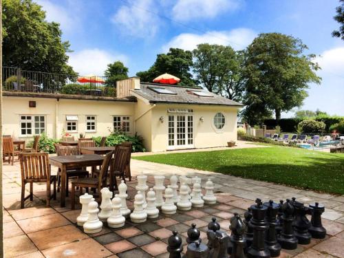 un tablero de ajedrez en un patio con una casa en Stoke Lodge Hotel en Stoke Fleming