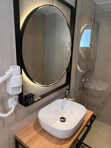 a bathroom with a white sink and a mirror at Thealos Santorini ( close to square) in Pirgos