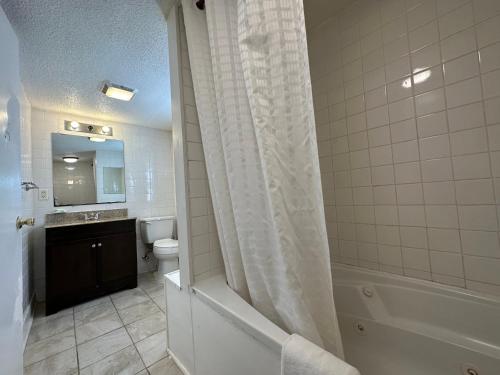 uma casa de banho com um chuveiro, um WC e um lavatório. em Budget Inn em Dayville