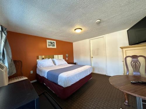 um quarto de hotel com uma cama e uma mesa em Budget Inn em Dayville