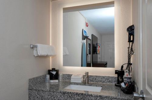 baño con lavabo y espejo grande en Red Roof Inn Gulf Shores, en Gulf Shores