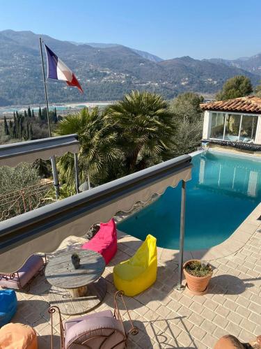- une piscine avec des chaises colorées à côté d'une maison dans l'établissement charmante villa, à Saint-Martin-du-Var
