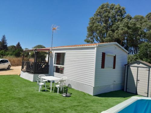 a small white shed with a table and chairs in a yard at La Muela in Cádiz