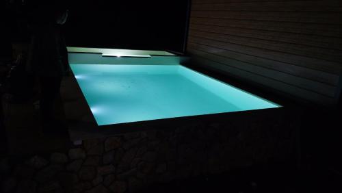 una piscina con luz azul en una habitación oscura en Bungalovi Ključ en Ključ