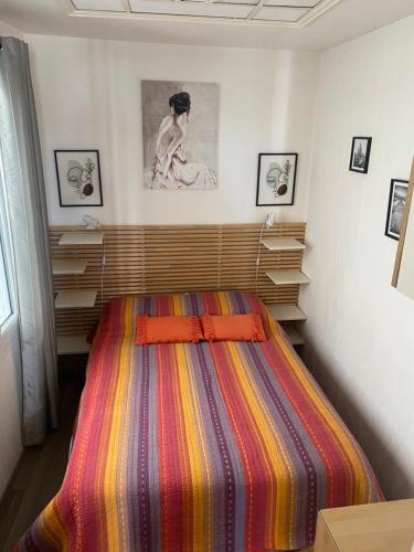 - une chambre avec un lit et une couverture rayée colorée dans l'établissement Le rêve Trouvillais, à Trouville-sur-Mer