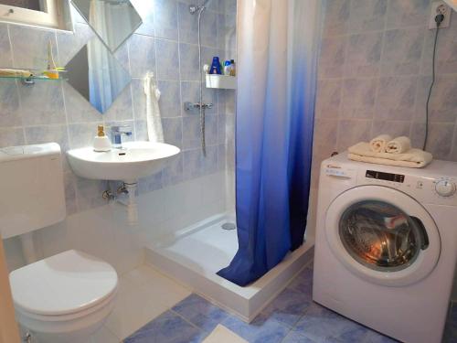 uma casa de banho com uma máquina de lavar roupa e um lavatório em Christie's Downtown Apartment em Budapeste