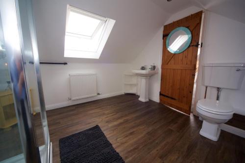 a bathroom with a toilet and a window and a sink at Creggans Cottage in Creggans