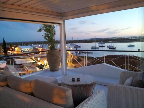 a living room with a large window with a view of a harbor at Portobello River and Sea View in Alvor