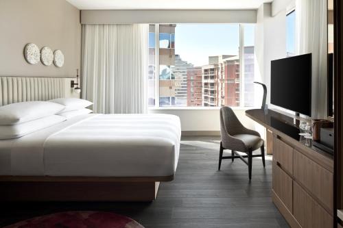 a hotel room with a bed and a desk and a television at Marriott Bethesda Downtown at Marriott HQ in Bethesda