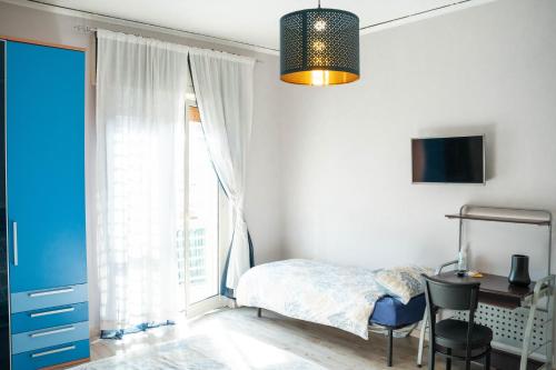 a bedroom with a bed and a desk and a window at BEDandFLY in Naples