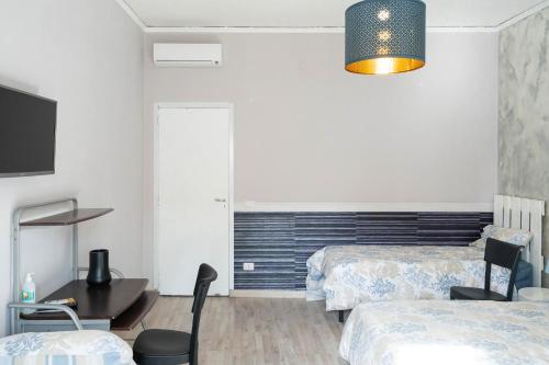 sypialnia z 2 łóżkami, biurkiem i telewizorem w obiekcie BEDandFLY w mieście Napoli