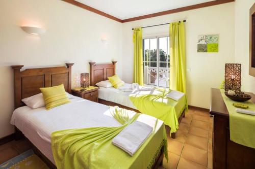 una camera d'albergo con due letti e una finestra di Casa Bonita (Terraços de Benagil 37) a Lagoa