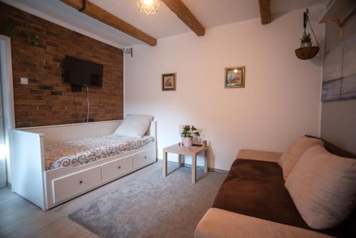 ein Wohnzimmer mit einem Bett und einer Ziegelwand in der Unterkunft Nordic Dream Apartment in Kikinda in Kikinda